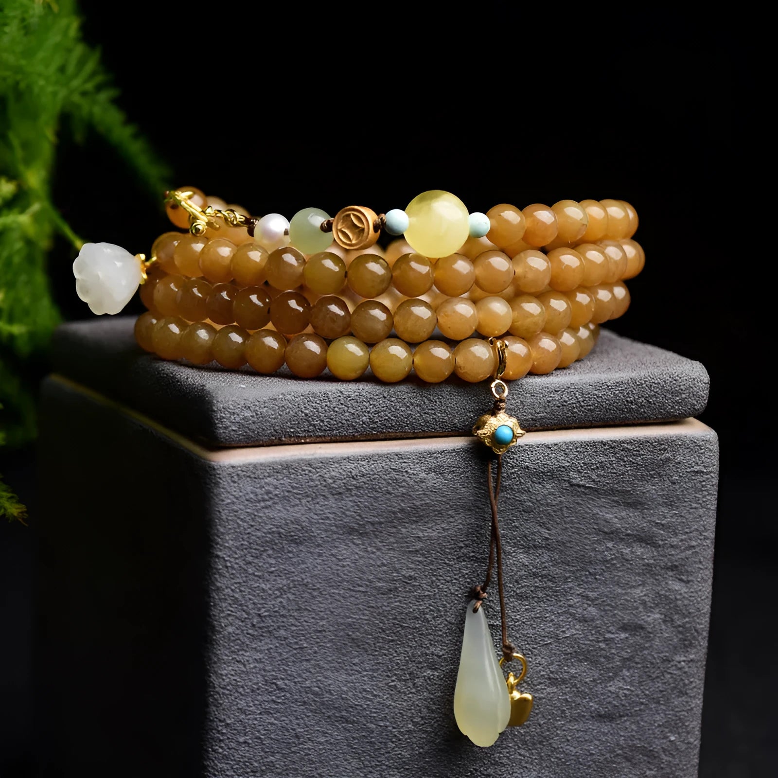 Green jade bead bracelet with leaf shapes and sequins on wrist