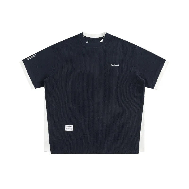 Loose waffle-knit short-sleeved t-shirt with retro alphabet embroidery on the front, shown in navy blue.