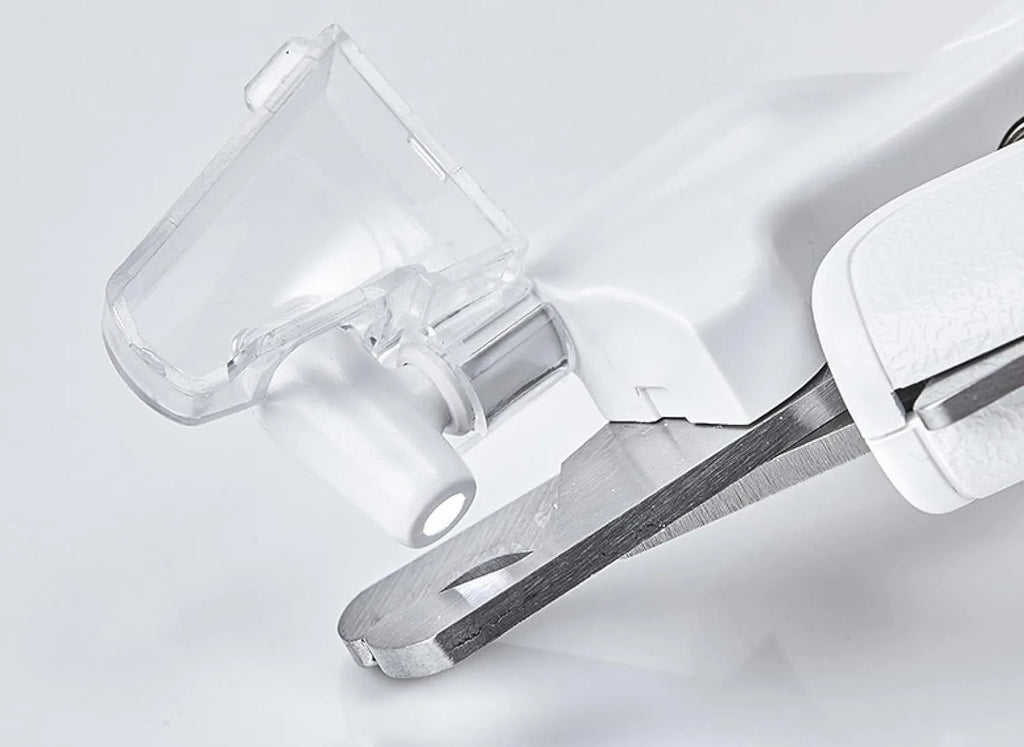 White pet nail clippers with LED light, transparent guard, and nail file on a grey background.