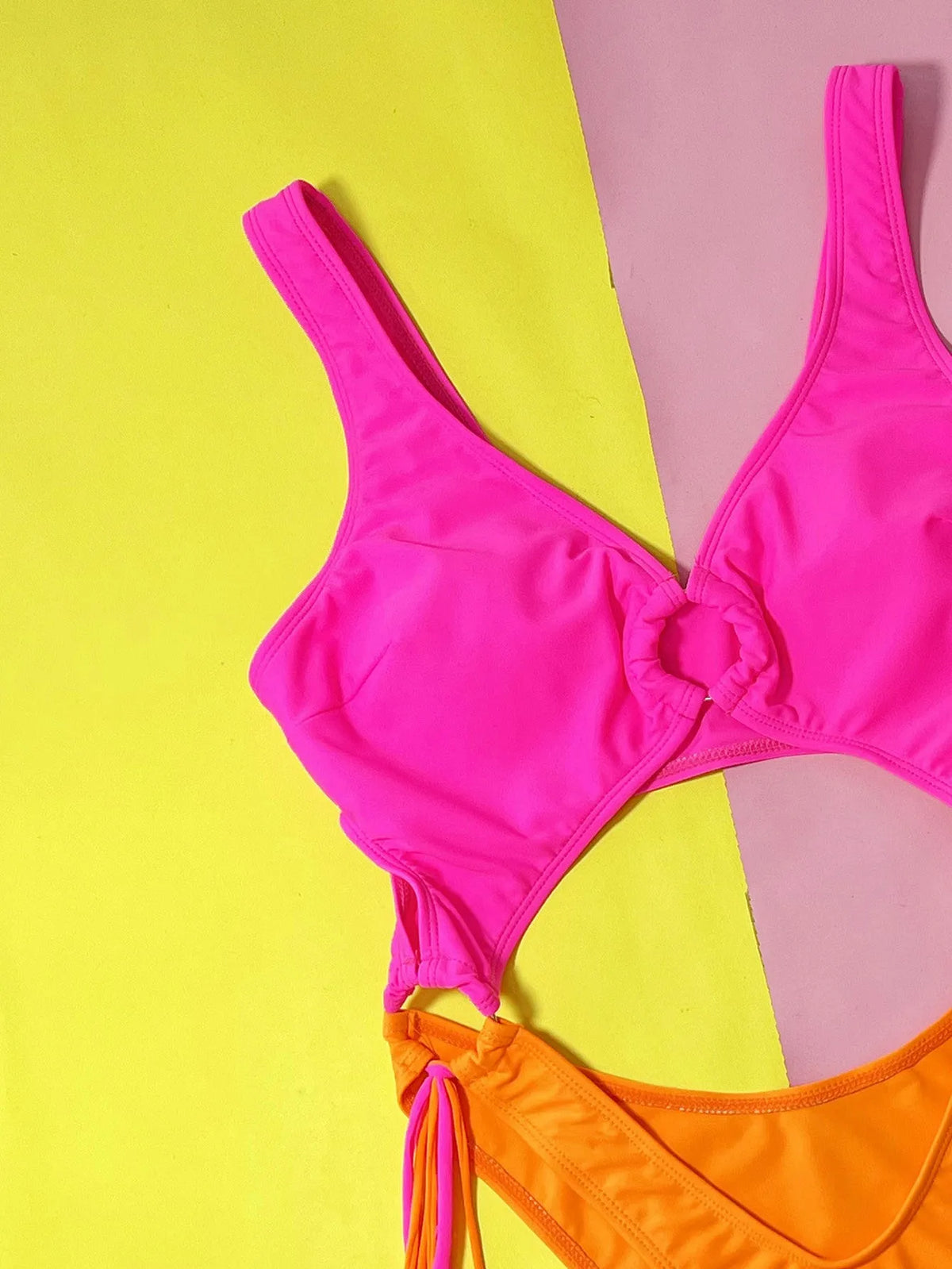 Women's rose red hollow-out steel ring tassel one-piece swimsuit on display