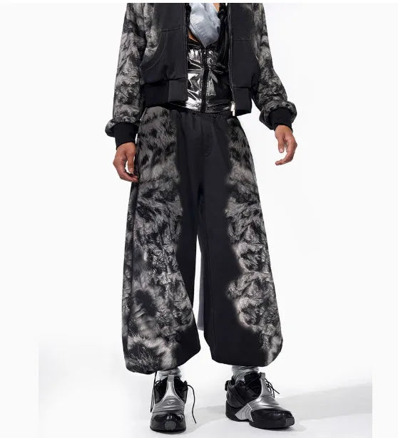 Woman wearing a loose-fit printed collage trouser and matching hoodie from a streetwear set.