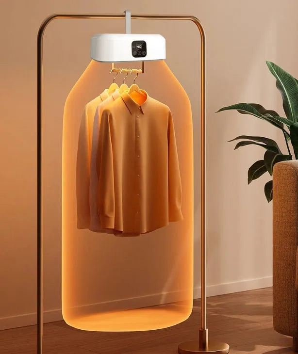 White cylindrical foldable clothes drier with remote control on a table.