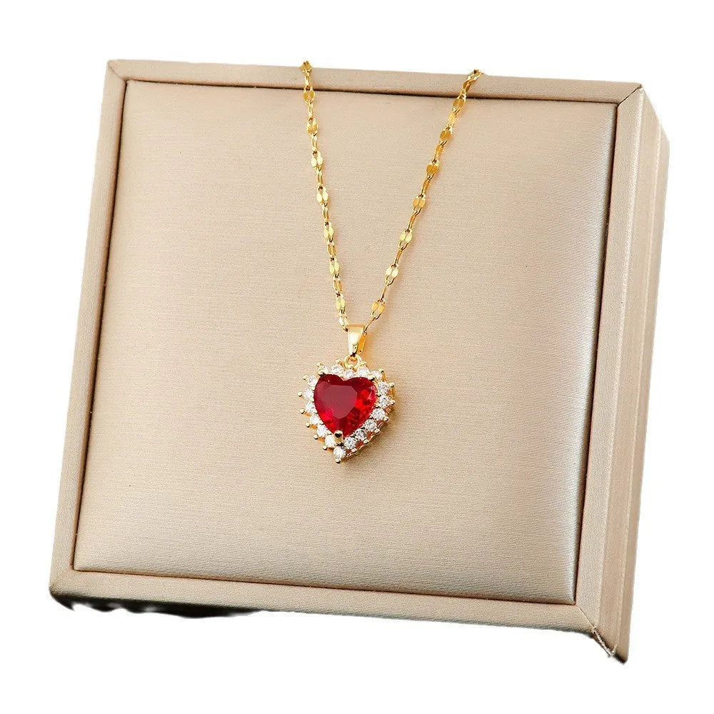 Gold-red heart and flower pendant necklace with gemstone inlay on a titanium steel water wave chain, part of a matching jewellery suit.