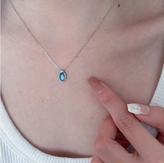 Geometric navy blue water droplet pendant necklace on a platinum-coloured adjustable chain.