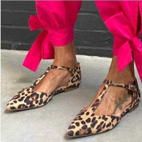 Women's low-top leopard print pumps with a chunky heel and cross shoulder straps on a pointed toe.