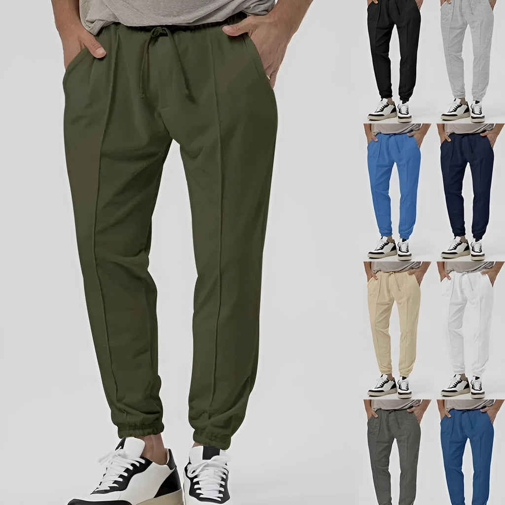 Men's grey cotton blend track sweatpants with a loose tapered fit and straight leg on a mannequin.