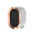 Compact black desktop electric ceramic fan heater with control knob on a wooden desk.