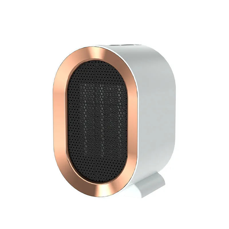 Compact black desktop electric ceramic fan heater with control knob on a wooden desk.