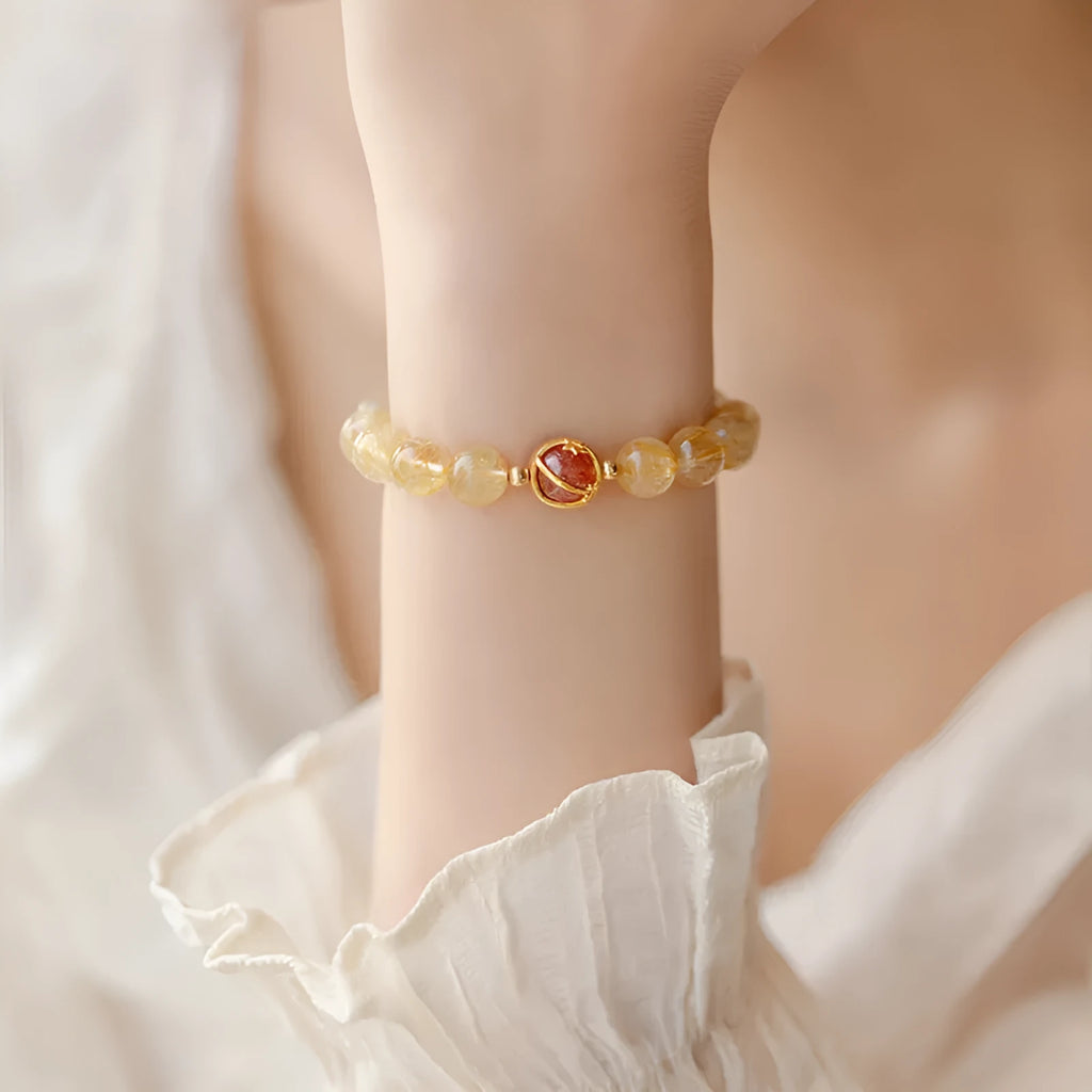 Gold rutilated quartz crystal bracelet with diamond-shaped links and natural citrine beads