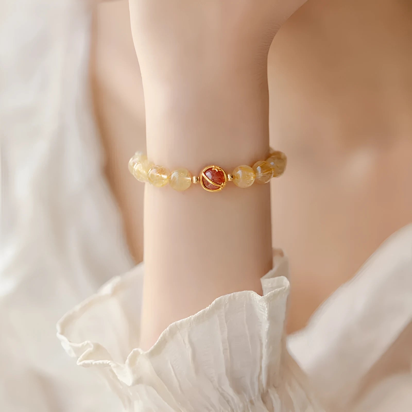 Gold rutilated quartz crystal bracelet with diamond-shaped links and natural citrine beads