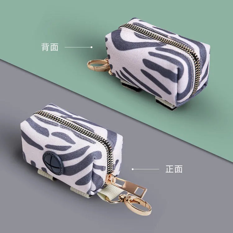Compact polyester pet poop bag carrier with zipper closure and hand strap in forest bag print