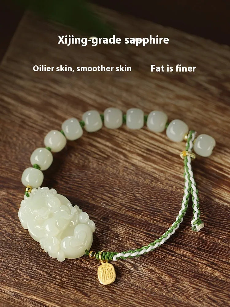 Year of the Rabbit red cord bracelet with Hetian jade charm and small silver blessing card.