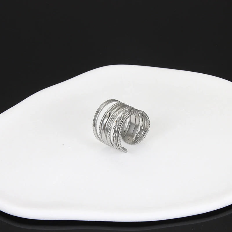 Adjustable stainless steel finger ring with unique charm designs in steel and gold colours