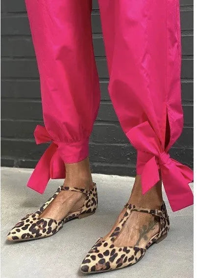 Women's low-top leopard print pumps with a chunky heel and cross shoulder straps on a pointed toe.