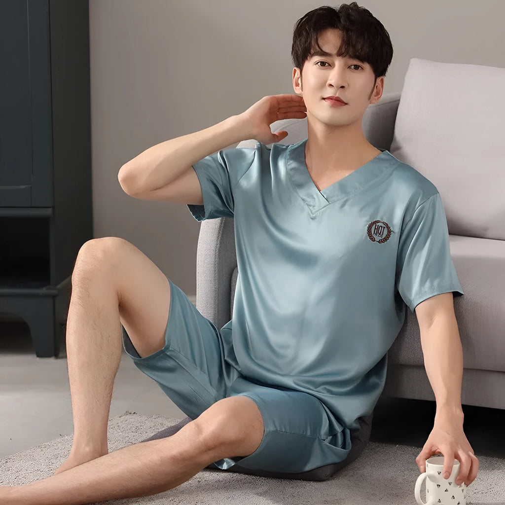 Man wearing a light blue loose short-sleeved ice silk pajama shirt and matching shorts.