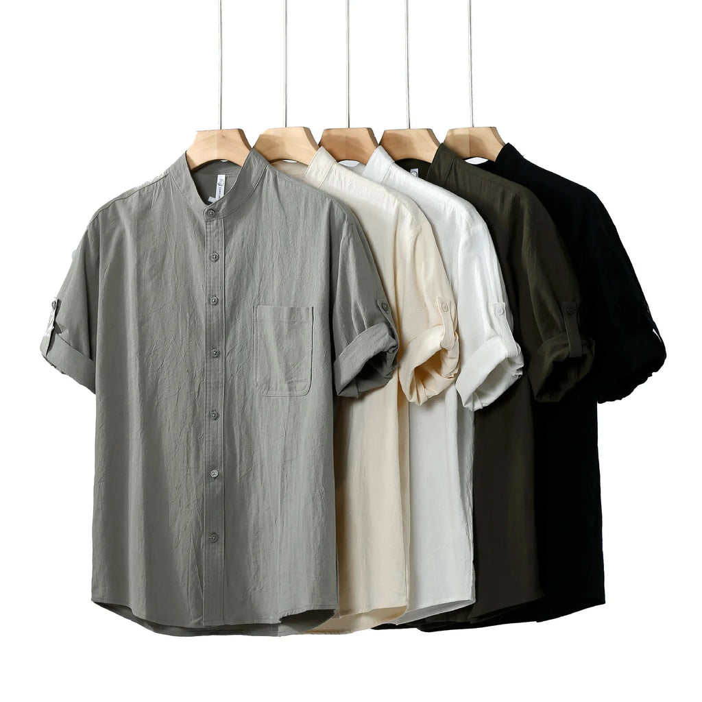 A man's loose-fitting, short-sleeved linen shirt in a solid colour with a stand collar.
