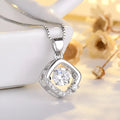 Silver heart-shaped necklace with crown and bow charms on clavicle
