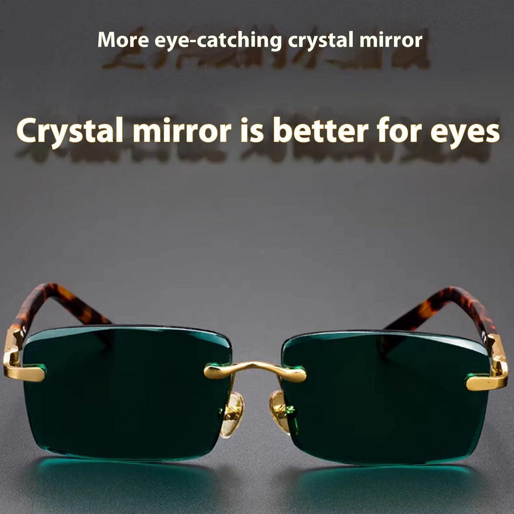 Dark green crystal frameless sunglasses with a case and cleaning cloth on a table.