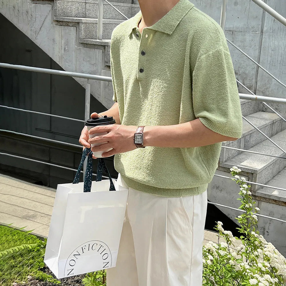 Man modelling a caramel coloured loose-fit knitted short sleeve polo shirt with an asymmetric design.