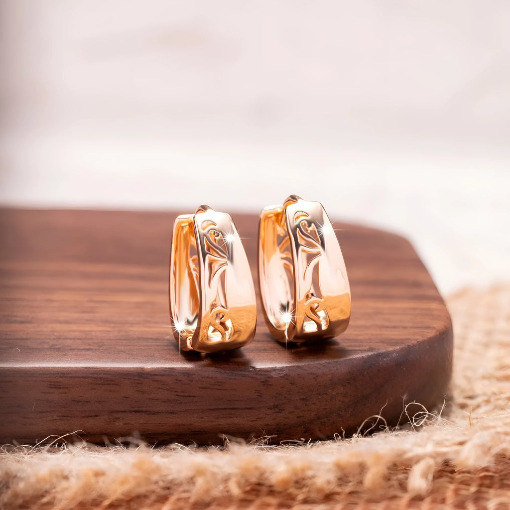 Rose gold copper hollow carved U-shaped women's earrings on a neutral background