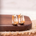 Rose gold copper hollow carved U-shaped women's earrings on a neutral background