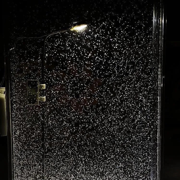 DIY snowy night light kit showing a small assembled street lamp with LED lights on a snowy flowing water landscape
