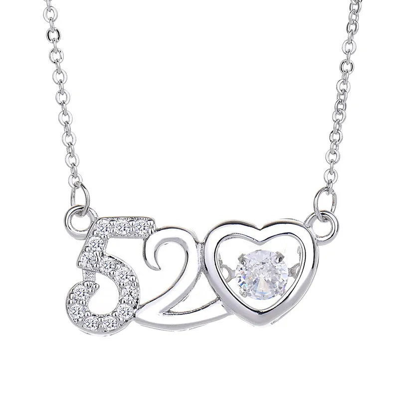 Silver heart-shaped necklace with crown and bow charms on clavicle