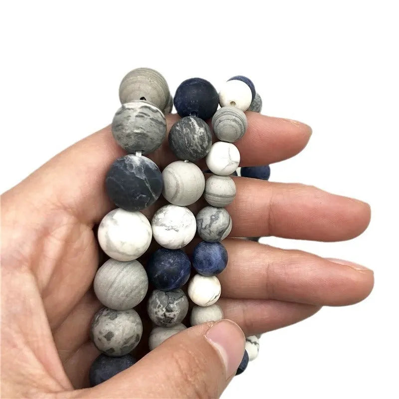 Handmade natural planet stone bracelet with starry design on a wrist, showing U-shaped profile.