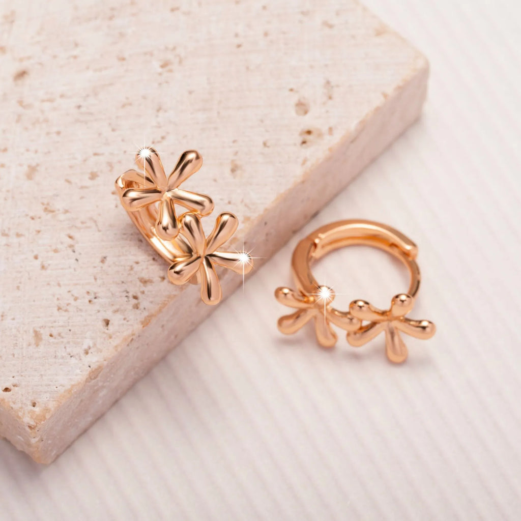 Rose gold circular earrings with a waterdrop flower design.