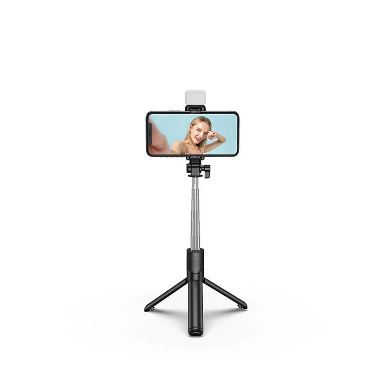 Black Bluetooth selfie stick tripod with fill light extended, holding a smartphone.