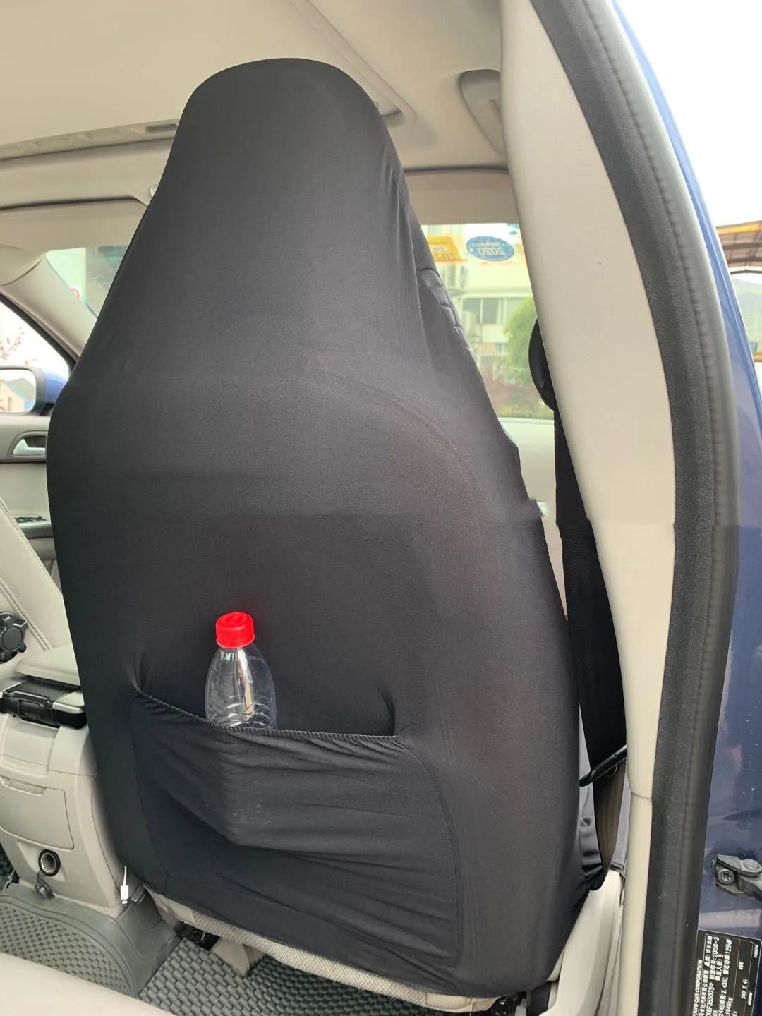 Black quilted car seat cover made of PU and polyester fabric with sponge padding.
