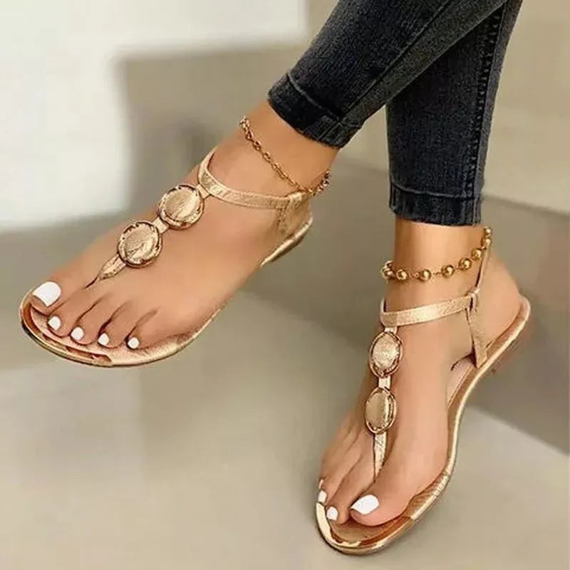 Women's flat sandals with metal buckle detail and round toe in black artificial PU upper