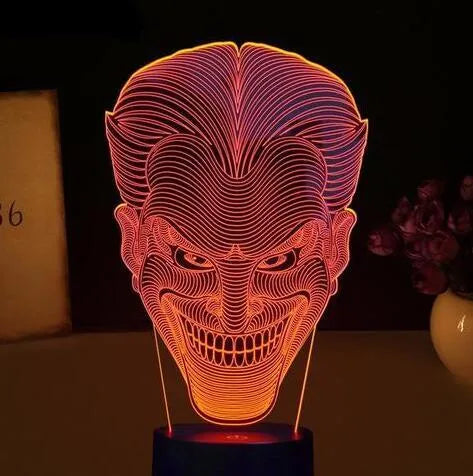 A 3D acrylic LED table lamp displaying colourful light patterns, with a remote control and USB cable.