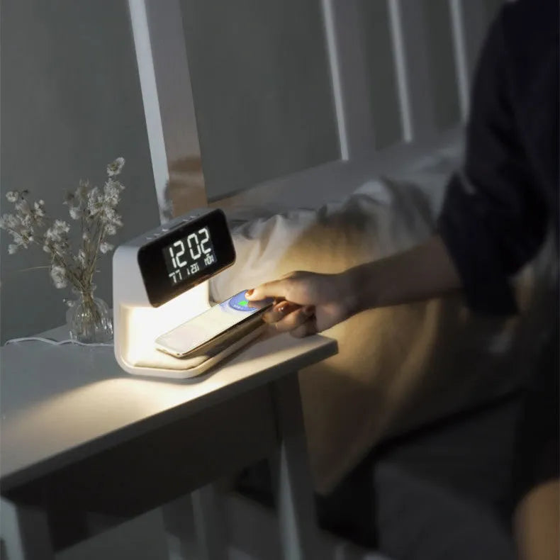 White 3-in-1 bedside lamp with wireless charging pad, LCD alarm clock screen, and touch-sensitive dimming control.