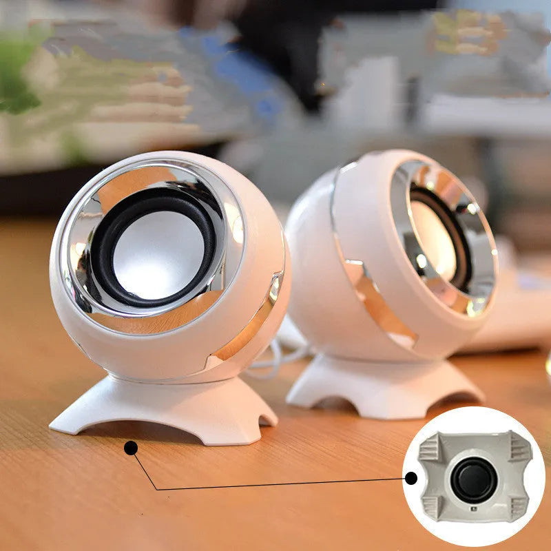 Compact black and gold USB-powered stereo desktop speakers next to a laptop.