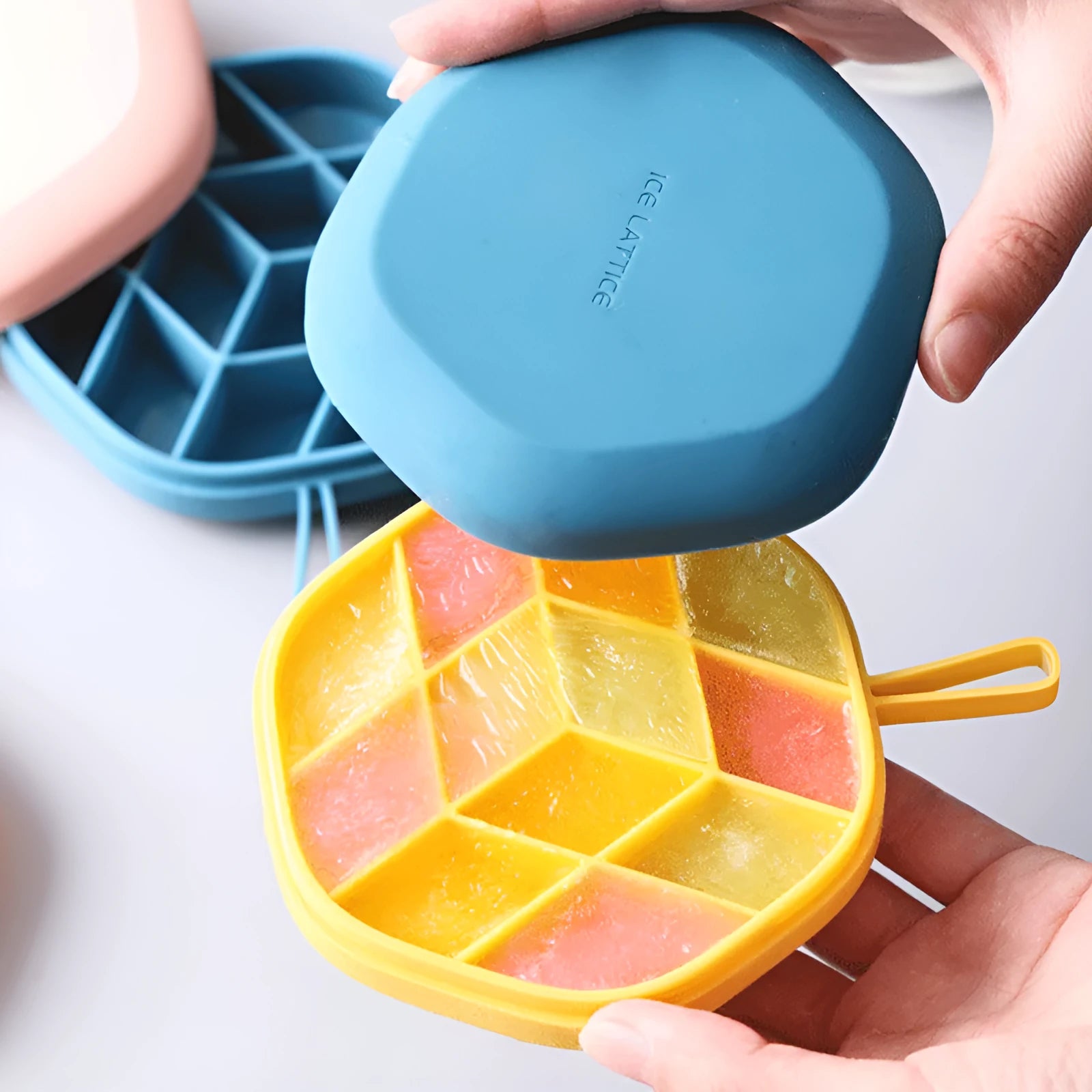Blue silicone 12-cavity hexagon ice cube mould with silicone cover on white background