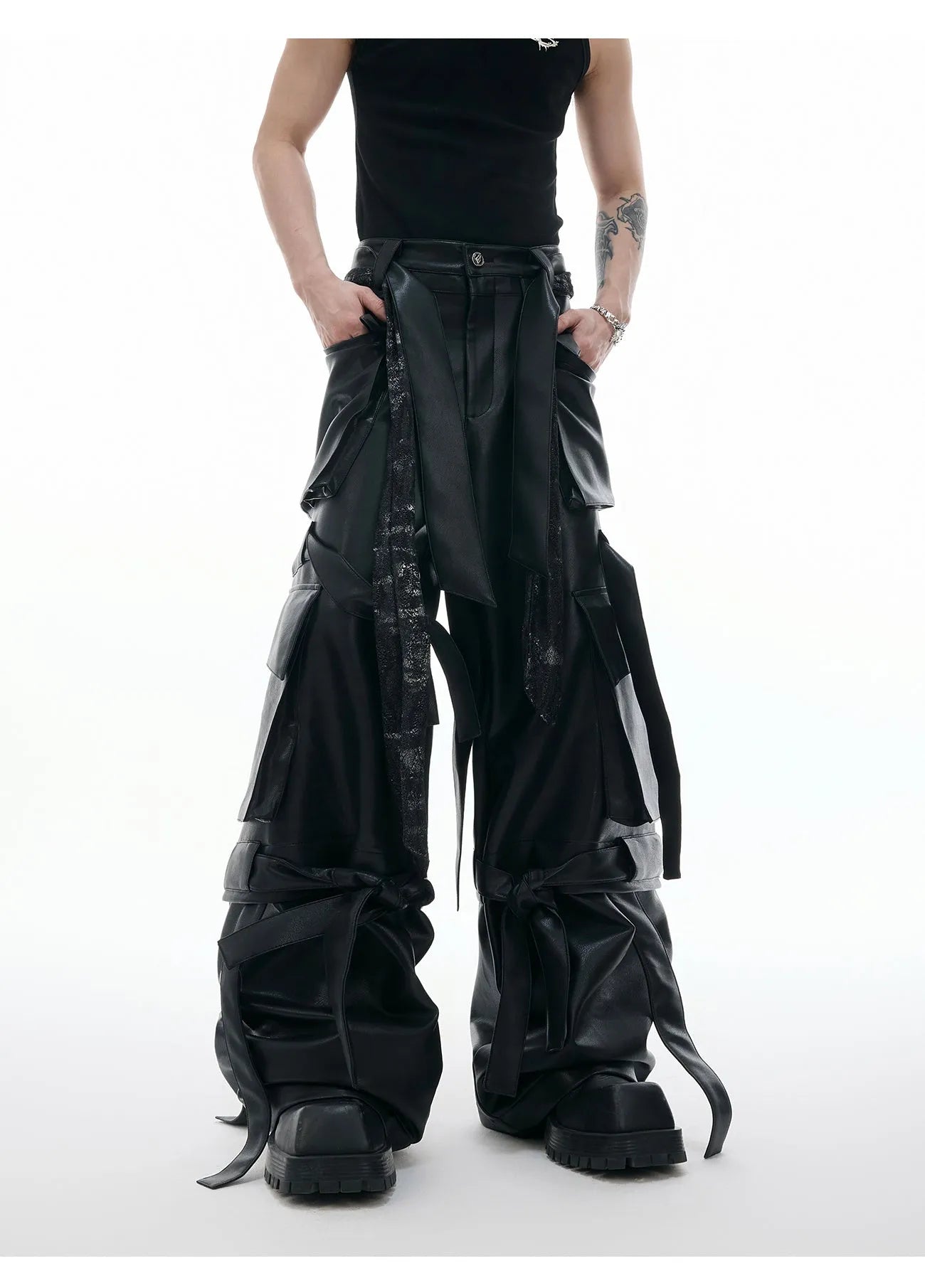 Black loose-fit leather-look trousers with multiple pockets, quilted panels, and ribbon trim details.