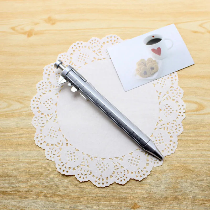 A multifunction orange ballpoint pen with a built-in silver slide vernier caliper, 15cm long.