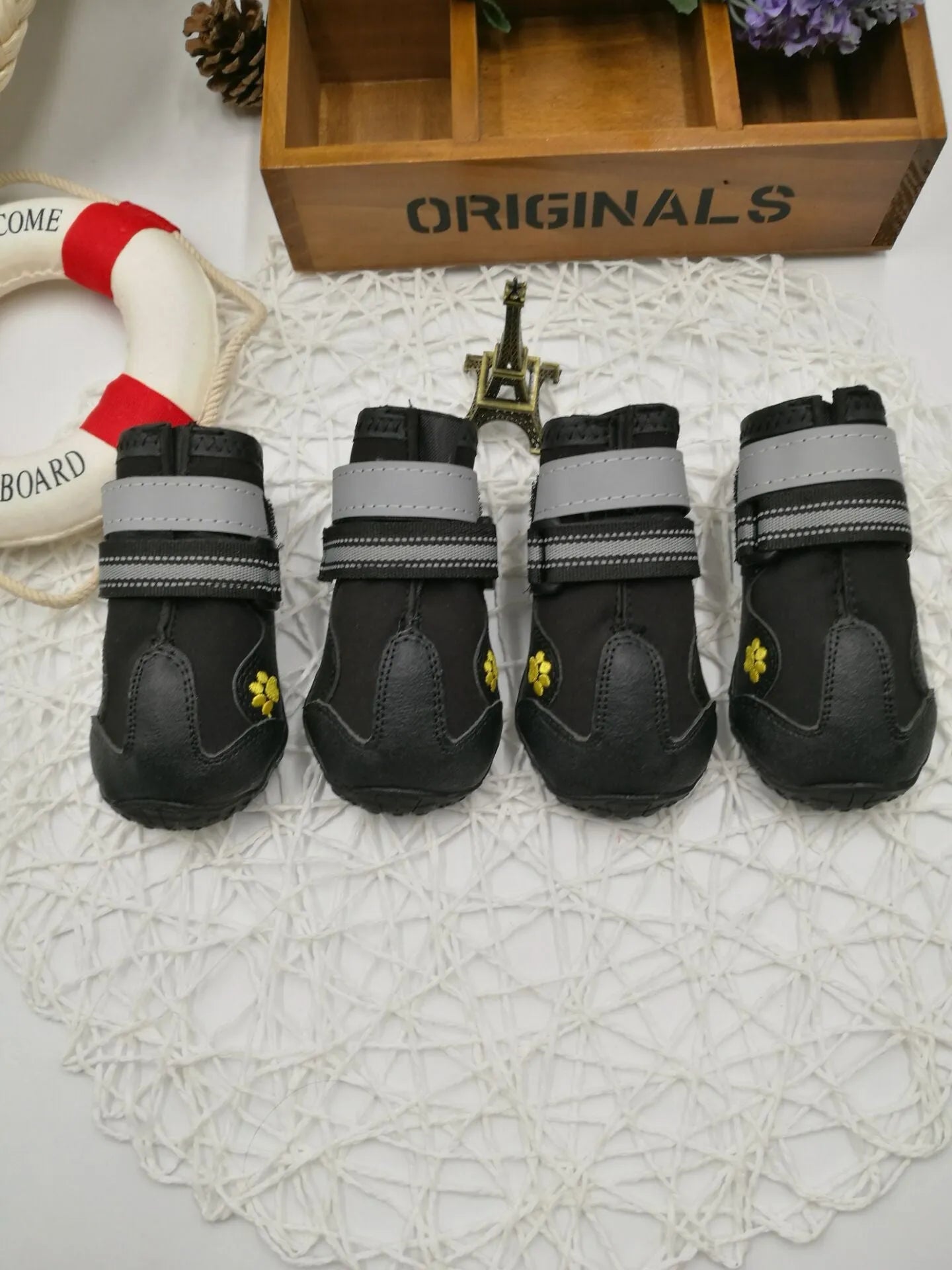 Black dog shoes with waterproof PVC sole and adjustable fuzzy belt on a white background
