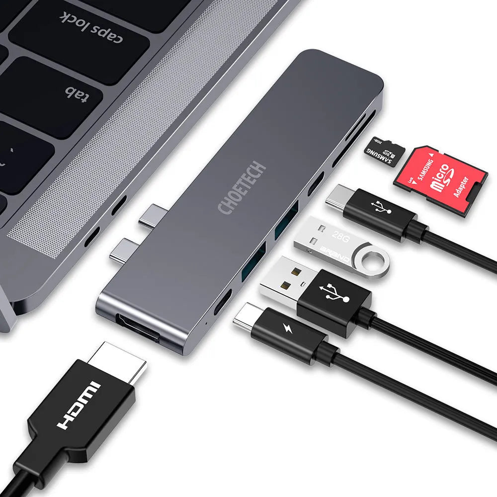 Silver aluminium USB-C hub adapter with SD card slot, HDMI, USB ports, and Thunderbolt 3