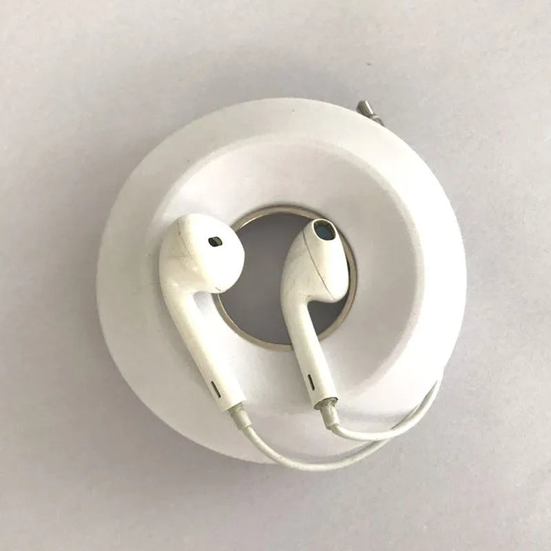 Donut-shaped silicone cord reel with suction cup base and magnet ring for organising cables