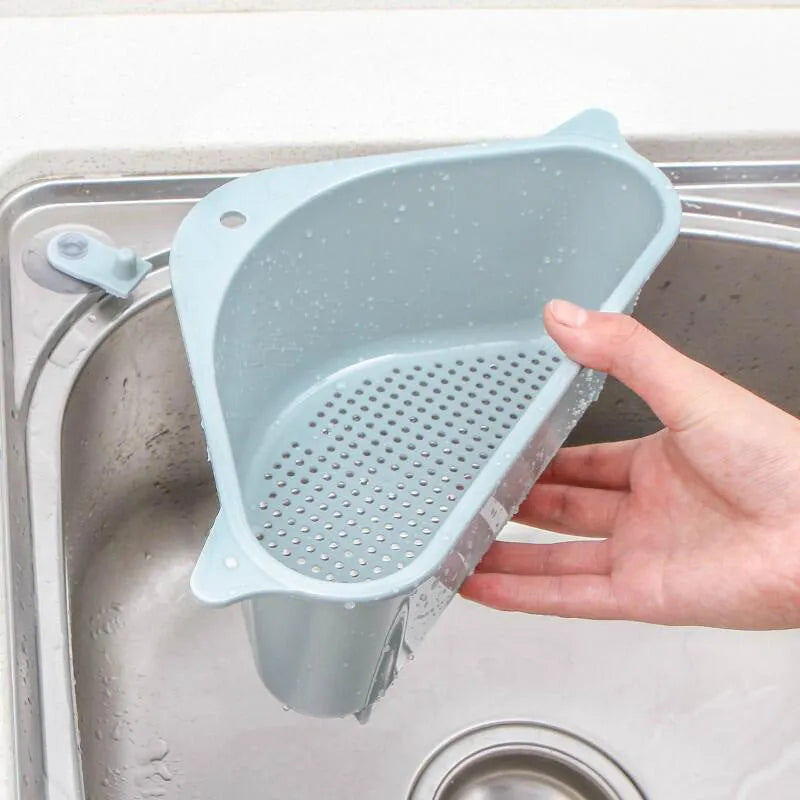 Beige plastic triangle sink storage rack for draining sponges, shown mounted on a kitchen faucet.