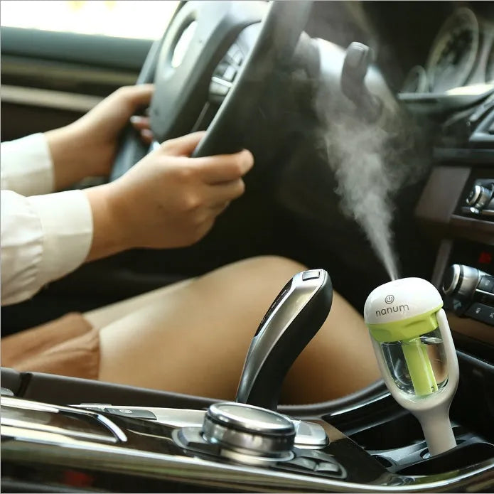 Compact portable car humidifier and air freshener unit with 180-degree rotating mist nozzle.
