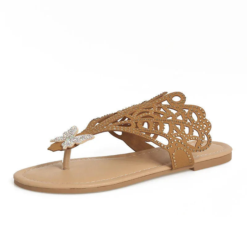 Women's black slip-on sandals with rhinestone decoration and a flip-toe design on a light background.