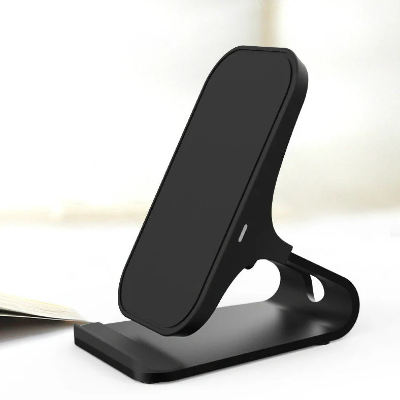 Black wireless charging pad with smartphone positioned vertically on metal surface