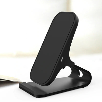 Black wireless charging pad with smartphone positioned vertically on metal surface