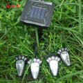 Black solar powered animal paw print LED garden lights set of four with central solar panel