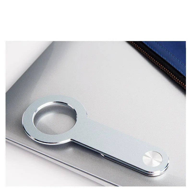 Silver aluminium alloy magnetic extension holder for mobile phones on a desktop.