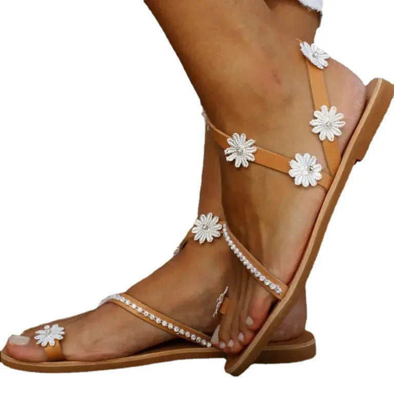 Brown ladies' Roman sandals with floral pattern and herringbone toe detail on a flat rubber sole.