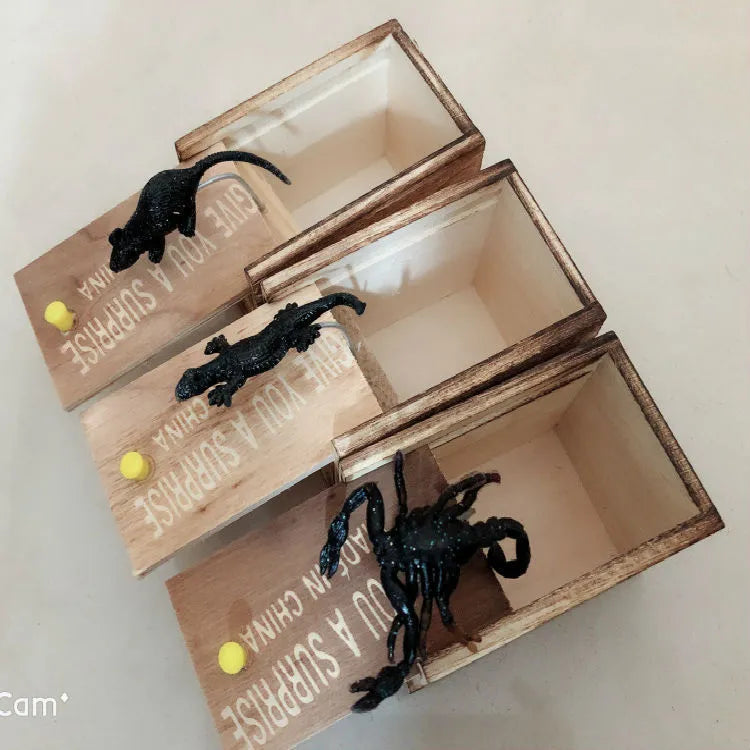 Wooden prank scare box closed on table, with random jumping animal surprise inside for April Fools' tricks.